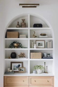 a white bookcase filled with lots of books and vases on top of it