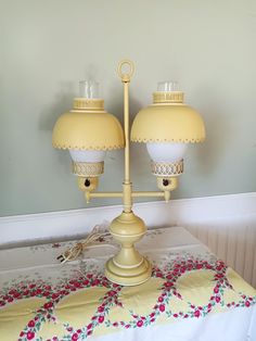 two yellow lamps sitting on top of a table