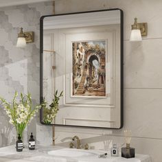 a bathroom sink with a painting on the wall above it and two vases filled with flowers