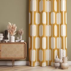 a living room with a yellow and white curtain next to a brown cabinet in front of it