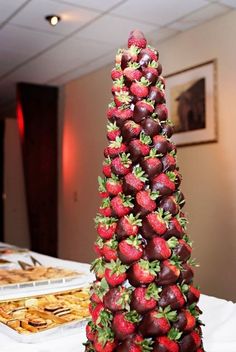 there is a very tall tower made out of strawberries and chocolate covered strawberries