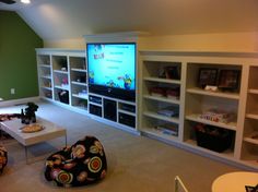 a living room filled with lots of furniture and a flat screen tv mounted to the wall