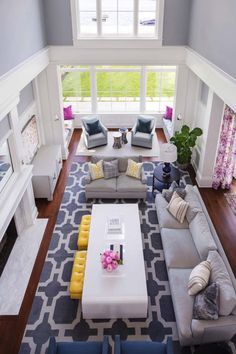 an aerial view of a living room with gray couches and yellow accents