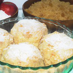 a glass bowl filled with powdered sugar next to two bowls of apples and other desserts