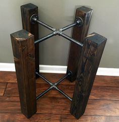 two wooden stands with iron bars on them sitting on a wood floor in front of a gray wall