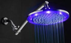 a shower head with blue leds and water running down it's side wall