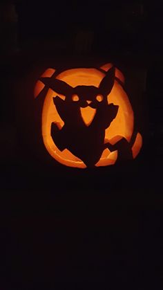 a carved pumpkin with an image of pokemon on it's face in the dark