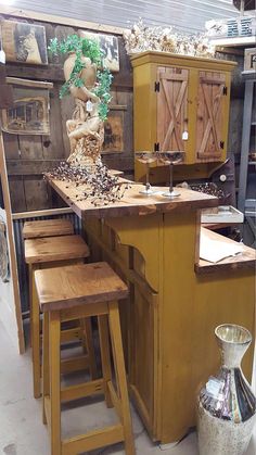 a kitchen island with stools next to it in a room filled with wooden cabinets