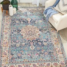 a large blue rug with an ornate design on the floor in front of a white chair