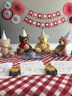 teddy bears sitting at a table with birthday decorations