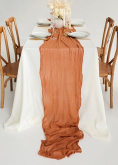 the table is set with an orange linen runner