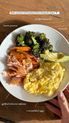 a white plate topped with eggs, ham and broccoli next to other foods