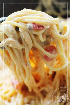 a spoon full of spaghetti with bacon and cheese