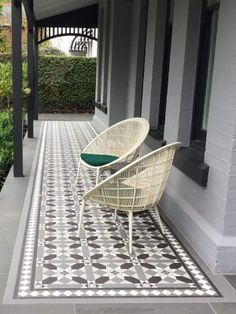 a white chair sitting on top of a black and white tile floor next to a building