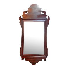 an old fashioned wooden mirror hanging on the wall