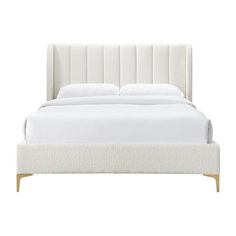 a bed with white sheets and pillows on it