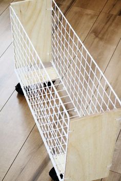 a white wire basket sitting on top of a wooden floor