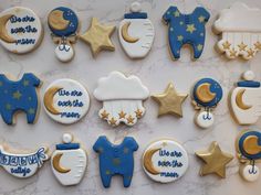 decorated cookies are arranged in the shape of stars, moon and baby's clothes