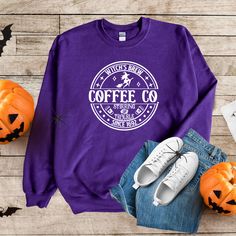 a purple sweatshirt with the words coffee co on it next to pumpkins and other items