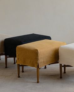 three different colored footstools sitting on top of each other in a living room