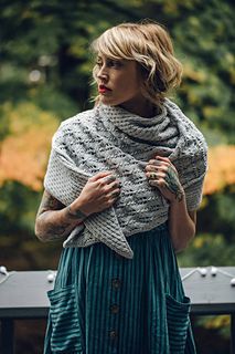 a woman wearing a knitted shawl and smiling