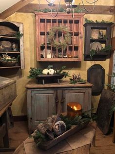 an old fashioned hutch is decorated with greenery and candles