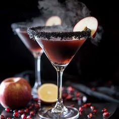 two glasses filled with liquid next to an apple