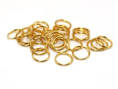 gold plated jump rings on a white background with clippings in the middle