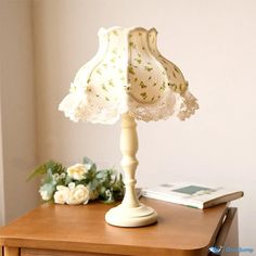 a white lamp sitting on top of a wooden table