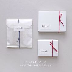 two white envelopes with red string tied to them