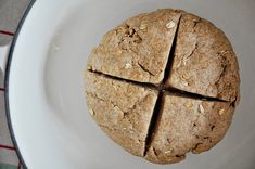 a white plate topped with a cut in half oatmeal cookie on top of a table