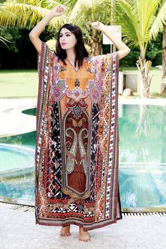 Want to shop for a dress that is comfortable, classy and elegant at the same time? Then this alluring Silk Kaftan dress with glittering crystal work is the best choice for you. The minimal V neckline sets a perfect combination with sassy sidelines of the silk Kaftan dress. The beauty of brown shade is more evident with tinge of orange, maroon, black and white. Swim wear kaftan Style it with white earrings and white heels for a relaxing day at beach. ONE SIZE FIT ALL KAFTAN ( Small to 8XL) Materi Multicolor V-neck Dress For Eid, Printed V-neck Dress For Eid, Long Bollywood Style Dress For Festival, Bollywood Style Long Dress For Festival, Long Bollywood Festival Dress, Bohemian Printed Dresses For Eid, Bohemian Long Dress For Eid, Long Tunic For Beach Eid, Long Tunic For Eid At The Beach