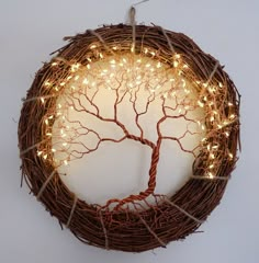 a wreath with lights hanging from it's sides and a tree in the middle