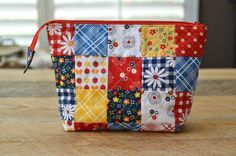 a colorful patchwork purse sitting on top of a wooden table