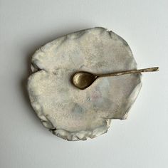 a spoon resting on top of a piece of pottery