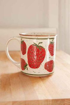 a coffee cup with strawberries painted on it