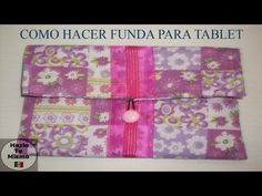 a pink and purple bag with flowers on it, sitting on top of a table