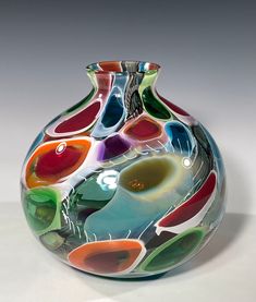 a multicolored glass vase sitting on top of a table