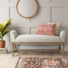 a white bench sitting next to a potted plant on top of a wooden floor