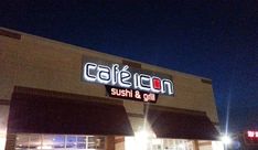 the exterior of a restaurant called cafe con sushi and grill at night with lights on