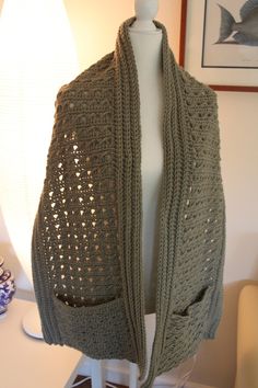 a crocheted shawl draped over a mannequin