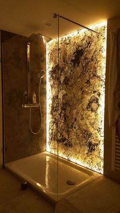 a bathroom with a glass shower stall and lights on the wall above it, along with a walk in shower