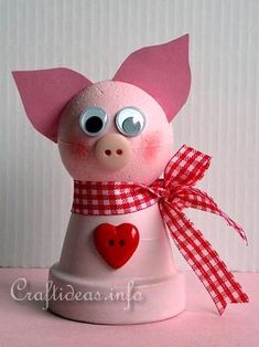 a pink pig figurine with a red heart on it's chest and eyes