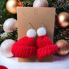 red and white knitted heart shaped earrings with pom - poms