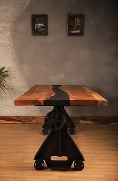 a wooden table sitting on top of a hard wood floor next to a potted plant