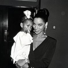 a black and white photo of a woman holding a child