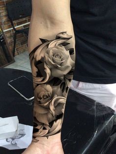 a person with a black and white rose tattoo on their arm