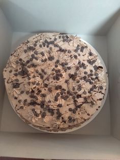 a cake in a box with chocolate chips and cream frosting on it's top