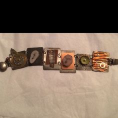 "I love making jewelry that has panels or individual pieces that I can create as individual little works of art.  Each of these 6 silver panels is approximately 1\" wide and 1-1.5\" high.  Each has a different set of created or found objects; including corrugate copper, enameled bead cap, polymer face cane, animal antler slice, and layered metal discs.  Cold connections are used primarily. There is a sterling silver clasp.  This is a real conversation piece.  All pieces are one of a kind." Unique Metal Cuff Bracelet For Jewelry Making, Artisan Silver Metal Bracelets, Silver Metal Bracelet With Custom Hardware, Artsy Metal Jewelry, Artisan Metal Bracelets Nickel Free, Artisan Silver Copper Cuff Bracelet, Stamped Metal Bracelet Jewelry, Handmade Metal Rectangular Bracelets, Artisan Silver-colored Copper Cuff Bracelet