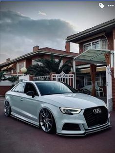 a white car parked in front of a house